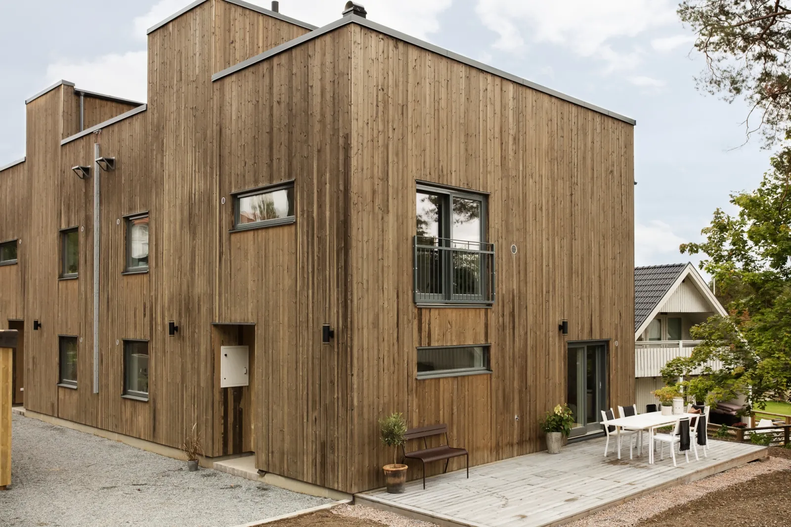 Hus i flera plan med fasad av stående träpanel